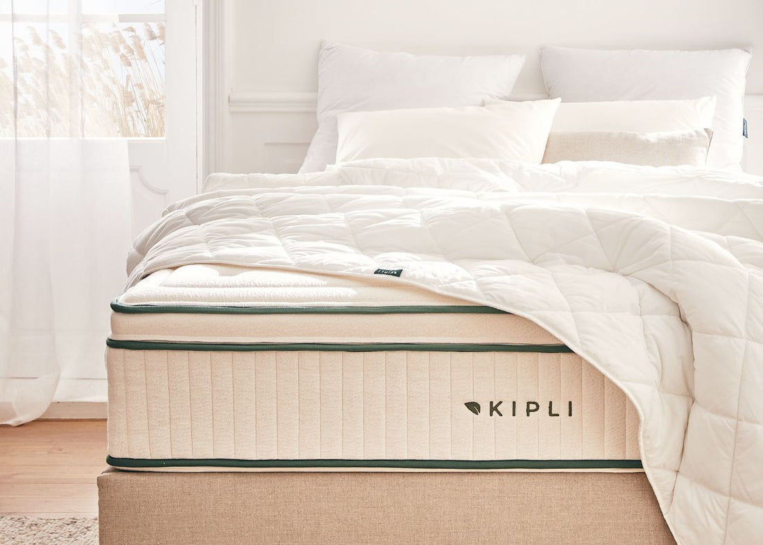 Matelas Kipli en latex naturel avec couette et oreillers blancs, illustrant une literie saine et durable dans une chambre lumineuse.