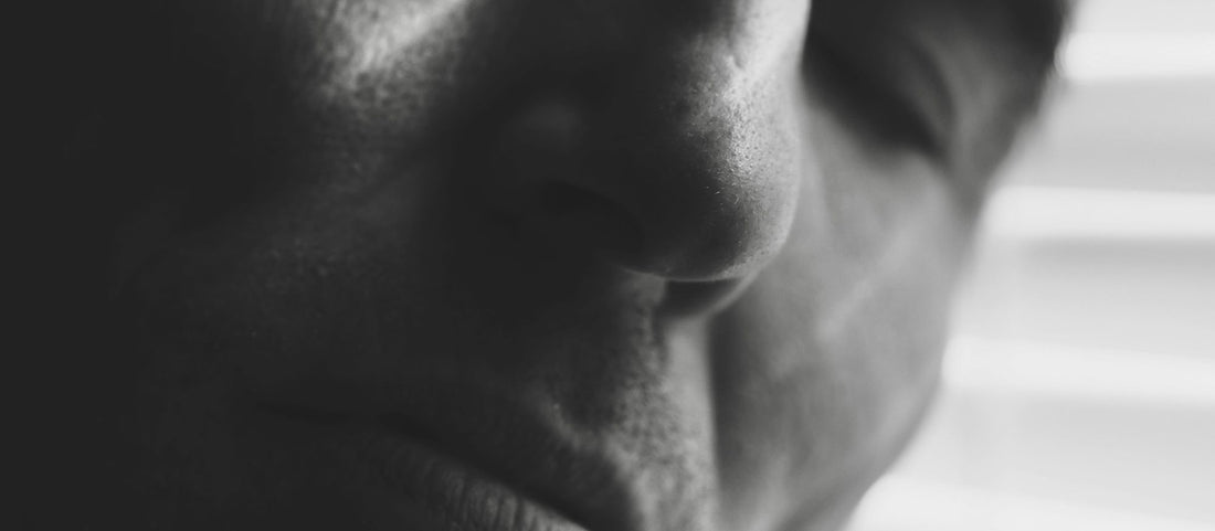 Visage d’une personne endormie en gros plan, photographié en noir et blanc.